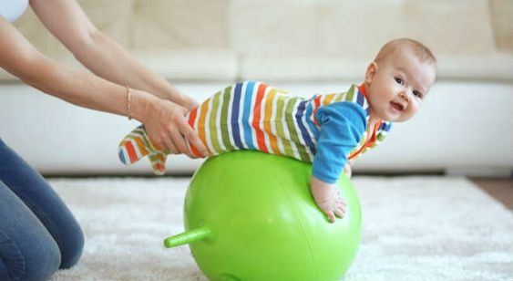 Bebé sobre una pelota inflada divirtiéndose